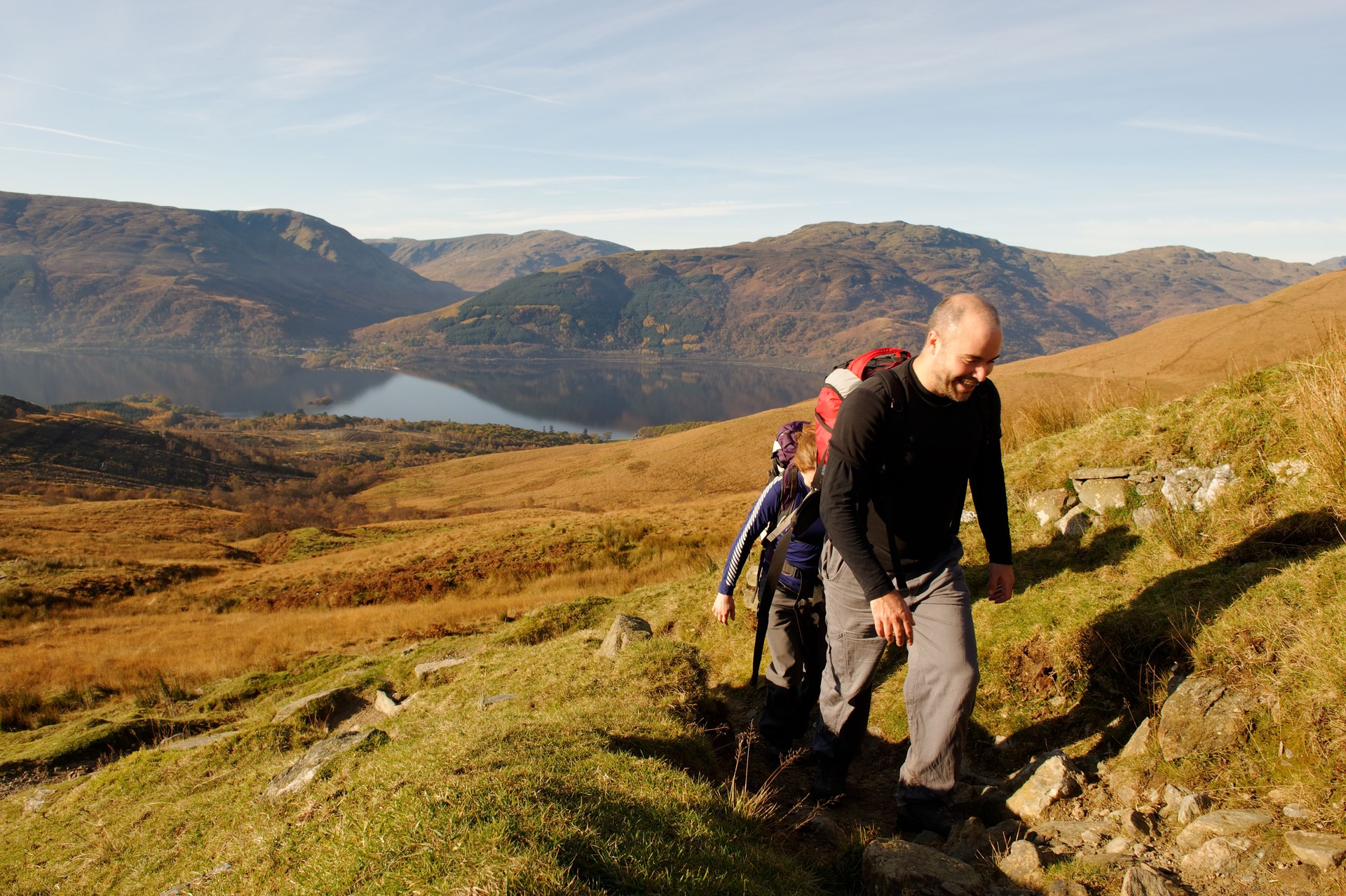 A man and a woman hiking together up a hill